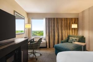 a hotel room with a desk and a chair and a television at Hampton Inn Pembroke Pines in Pembroke Pines