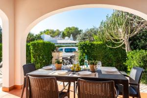 una mesa y sillas en un patio en Villa Thea, en Cala Blanca