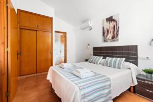 Un dormitorio con una gran cama blanca con toallas. en Villa Thea, en Cala Blanca 17 fotos más