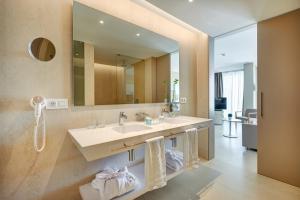 La salle de bains est pourvue d'un lavabo et d'un grand miroir. dans l'établissement Hipotels Gran Playa de Palma, à Playa de Palma