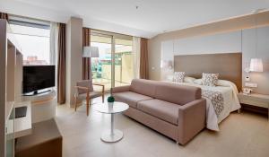 Habitación de hotel con cama y sofá en Hipotels Gran Playa de Palma en Playa de Palma