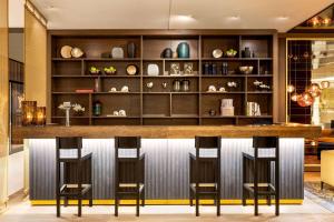 a bar in a restaurant with four stools at Vienna House by Wyndham Andel's Berlin in Berlin