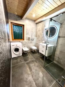 a bathroom with a washing machine and a washer at Highlander - drewniany dom w Beskidach in Kamesznica
