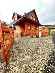 een houten huis met een hek ervoor bij Highlander - drewniany dom w Beskidach in Kamesznica