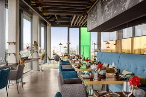 a restaurant with blue chairs and tables and windows at Vienna House by Wyndham Andel's Berlin in Berlin