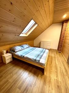 a bedroom with a bed in a wooden ceiling at Highlander - drewniany dom w Beskidach in Kamesznica