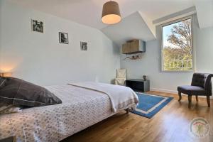 1 dormitorio con 1 cama, 1 silla y 1 ventana en Maison Saint LU, en Saint-Lunaire