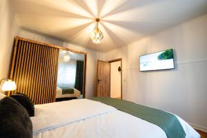 a hotel room with a bed and a flat screen tv at Fortuna Apartments in Baia Mare