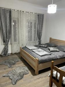 a bedroom with two beds and a window with curtains at Harmony cozy home in Podgorica