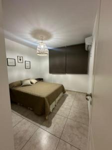 um quarto com uma cama e um lustre em Viaggiato Colon em Córdoba