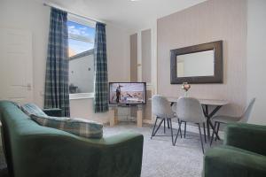 sala de estar con sofá, TV y mesa en Chic Home & Stylish Workspace in Outram, Sleeps 6, en Darlington