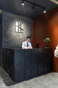 a man sitting at a counter in an office at Linn Hotel Bac Giang in Bắc Giang