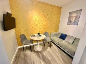 uma pequena sala de estar com uma mesa e um sofá em Urban Retreat - Close To Town and Beach em Bournemouth