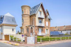 ブロンヴィル・シュル・メールにあるDeauville Spa Suite - 3min beachの路上の煙突のある古いレンガ造りの建物