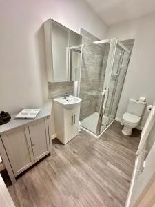 uma casa de banho com um chuveiro, um lavatório e um WC. em Urban Retreat - Close To Town and Beach em Bournemouth