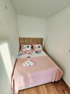 um pequeno quarto com uma cama com duas toalhas em Boutique apartman Dora Angel em Budva