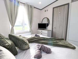 Un dormitorio con una cama con dos manoplas. en Ginger Fox Lodge en Ganton
