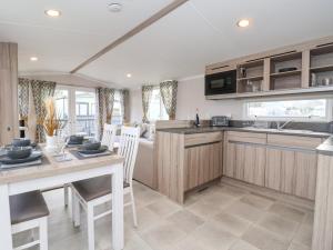 a kitchen and dining room with a table and chairs at Lazy Dayz Lodge in Ganton