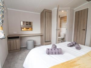 um quarto com uma cama branca com duas almofadas em Lazy Dayz Lodge em Ganton