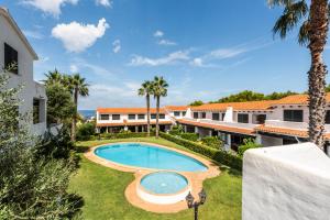 uma imagem de uma piscina num resort em Apartamento Arenal Jardin em Arenal d'en Castell