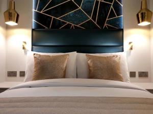 a bedroom with a bed with a black headboard and pillows at NOX Golders Green in London