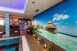 a room with a wall mural of a resort in the ocean at Hotel Sun in Senec
