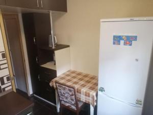 a kitchen with a refrigerator and a table and a chair at Квартиры по улице Феодосийская, 1-А in Kyiv