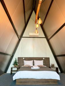 ein Schlafzimmer in einem Zelt mit einem Bett darin in der Unterkunft Green Village Pensiune in Roşu