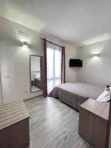 Habitación de hotel con cama y espejo en Affittacamere In Centro en Tortolì