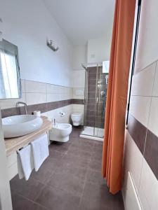 a bathroom with a sink and a toilet and a shower at Affittacamere In Centro in Tortolì +60 photos