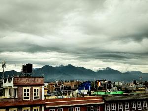 a city under a cloudy sky with mountains in the background at Badri Homes, Studio Apartment in Pātan