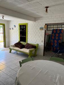 een woonkamer met een bank en een raam bij Hostel Casa Amarela in Porto De Galinhas