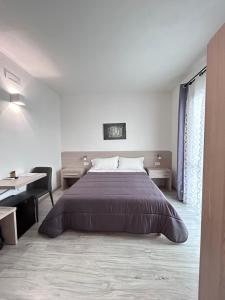 una camera con un grande letto e una scrivania di Affittacamere In Centro a Tortolì