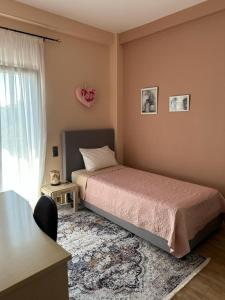 a bedroom with a bed and a table and a window at Αθανάσιος in Ioannina