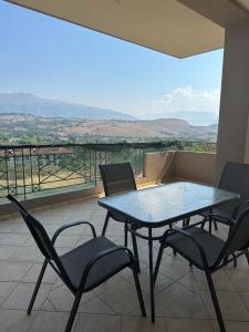 a table and chairs on a balcony with a view at Αθανάσιος in Ioannina