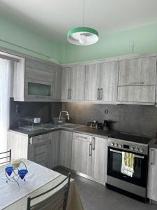 a kitchen with gray cabinets and a table and a stove at Αθανάσιος in Ioannina