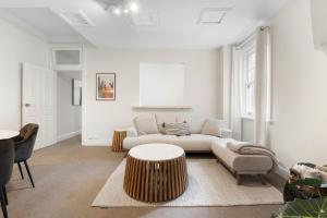 a living room with a couch and a table at Heritage Terrace with Harbour Glimpses for 6 in Sydney