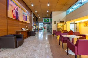 um restaurante com mesas e cadeiras num edifício em Hotel Nacional Inn Curitiba Estação Shopping em Curitiba