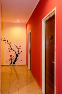 a hallway with orange walls and a tree mural on the wall at Victoria Inn, Penang in George Town