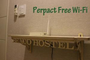 a shelf in a bathroom with a sign that reads papercraft free wifi at Bexco Hostel B&B in Busan
