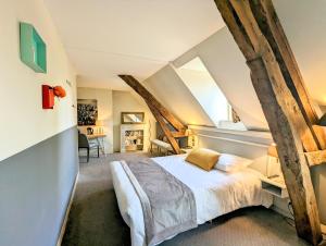 a bedroom with a large bed in a attic at Château Corneille in Vieux-Villez