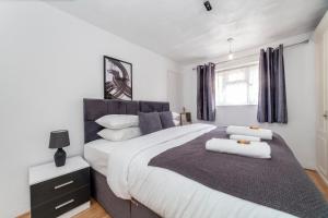 a bedroom with a large bed with two pillows on it at Stunning 3 Bed House with Private Garden, Woolwich in London
