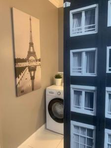 une salle de bains avec un lave-linge et une photo de la tour Eiffel dans l'établissement Nr 2 EUROPA22 Superior Apartament z balkonem JEST WINDA "Strzeżone Osiedle BROWARNA" CENTRUM MIASTA Opcjonalnie z garażem Quick Check-in, à Tomaszów Mazowiecki