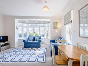 a living room with blue chairs and a table at 2 Bed in Swanage DC192 in Swanage