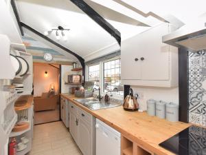 una cucina con armadi bianchi e ripiano in legno di 1 bed in Spalding 75073 a Surfleet