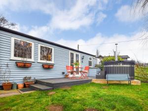 a blue house with a deck with a table and chairs at 1 bed in Spalding 75073 in Surfleet