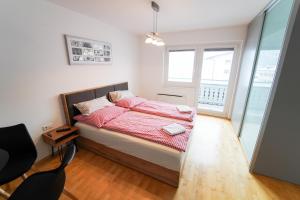 a bedroom with a bed and a large window at Schlafgut Küssler - 70m vom City Express in Zell am See