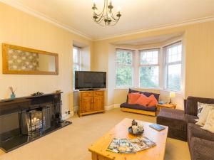 a living room with a fireplace and a tv at 5 Bed in Brodick CA016 in Brodick
