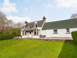 a white house with a green roof and a yard at 4 Bed in Kinlochewe CA179 in Kinlochewe