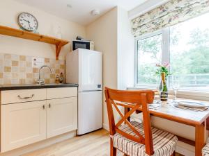 uma cozinha com uma mesa de madeira e um frigorífico branco em 1 Bed in Blacklunans CA361 em Cray